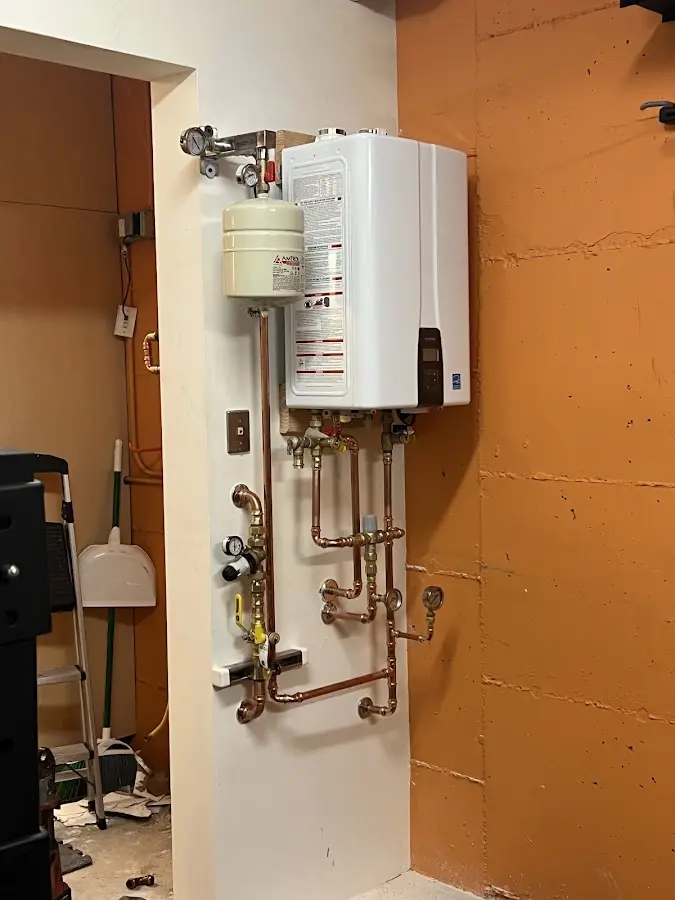 Plumbing technician inspecting water heater connections in Esperance